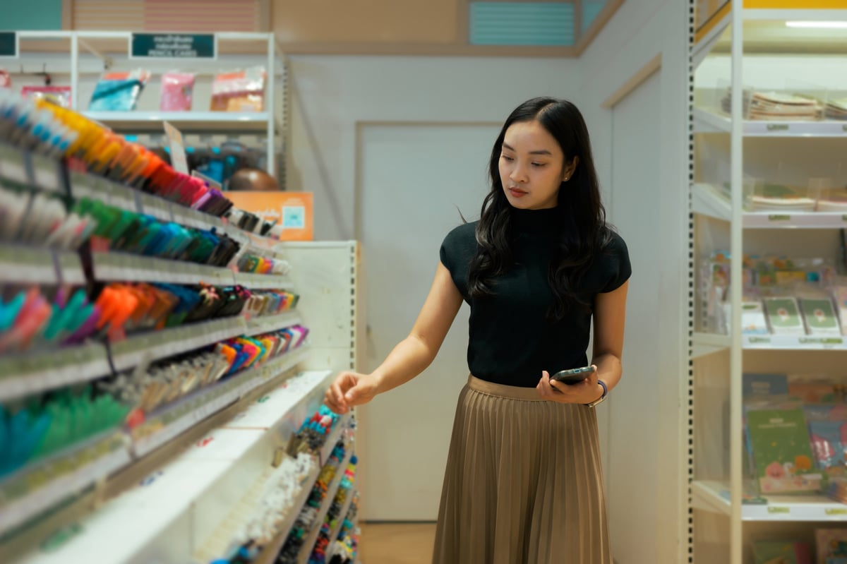 Joven comprando marcadores y artículos de papelería en una tienda